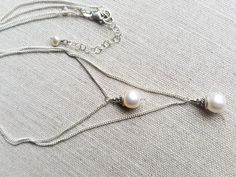 "Simple and elegant, this double strand pearl necklace will be a versatile piece in your wardrobe. Quality sterling silver cable chains hold one creamy white pearl on each (approximately 8 to10mm). Longer chain measures 18\", shorter chain measures 16\". Add length with included 2 inch extender chain." Elegant Silver Chain Layered Necklace, White Pearl Necklace With Silver Chain, Elegant White Necklace With Double Chain, Elegant Silver Pearl Layered Necklace, Elegant Cream Double Strand Necklaces, Elegant Double Strand Cream Necklace, Elegant Cream Double Strand Necklace, Silver Double Strand Pearl Necklace Gift, Silver Pearl Necklace With Delicate Chain