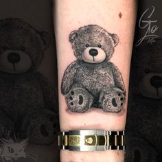 a black and white photo of a teddy bear on the left arm with gold accents