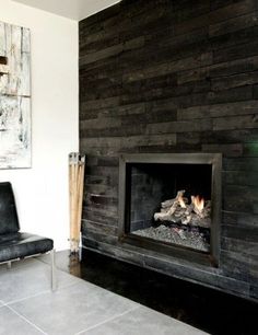 a living room with a fire place next to a chair and painting on the wall