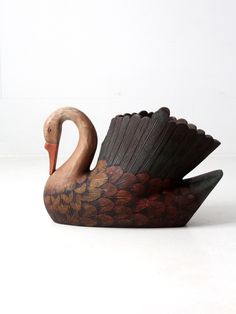 a wooden sculpture of a swan with flowers on it's body and wings spread out