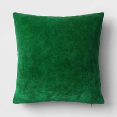 a green pillow on a white wall