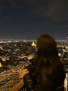 a woman looking out over the city at night