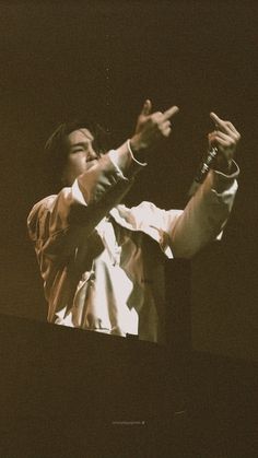 a man standing on top of a stage with his hands in the air and one hand out