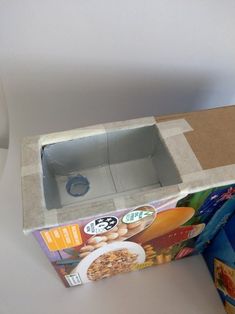 an open box sitting on top of a table next to a container filled with cereal