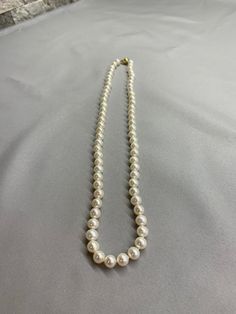 White Freshwater Pearl Necklace. This hand knotted necklace features 66 White Freshwater Pearls AAA High Luster Round to Near Round rose overtones 7.5-8mm. I hand knotted this necklace with white silk thread and finished it with a 14K yellow gold round polished bead clasp 8mm. The necklace measures 22 inches in length. The Pearls are Genuine and natural in color. This is a classic strand of pearls that can be worn for any occasion. These freshwater pearls are all nacre and will hold up well over Formal White Hand-strung Jewelry, Classic Round Hand-strung Jewelry, Timeless White Round Bead Necklace, White Hand Knotted Jewelry With Round Beads, Classic Hand-strung Round Bead Necklaces, Elegant Hand-strung Necklaces For Formal Occasions, Hand Knotted White Round Bead Jewelry, White Hand-strung Round Necklaces, Elegant Hand-strung Round Necklaces