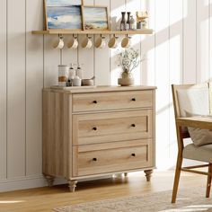 a wooden dresser sitting next to a wall with pictures on it's shelves and vases