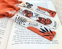 three butterfly bookmarks sitting on top of an open book