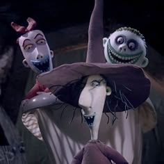 three creepy clowns wearing hats and costumes