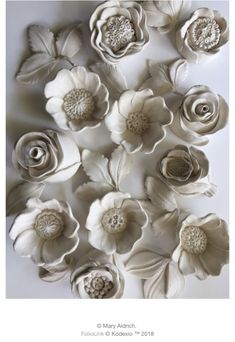 paper flowers are arranged on a white surface