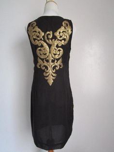 "This is a Glamorous Vintage Modern 1963DEX Made in INDIA Black Polyester and Golden Metallic Gold Sequin Embellished Shift Knee Midi Dress Cocktail Party Evening Special Occasion Size S M The style is a fully lined, shift dress with side invisible zipper, and heavily embellished metallic gold knee sequins front and back (never sit on sequins!). condition there is 1 very tiny hole/cut on the side of the dress, but it's not obvious, only if you stare at it really closely. Other than that, this lo Black Sleeveless Festive Dress, Festive Sleeveless Black Dress, Festive Black Sleeveless Dress, Black Embellished Dresses For Festive Occasions, Black Dress With Gold Embroidery For Party, Black Dress With Gold Embroidery For Festive Occasion, Festive Embellished Black Dress, Festive Black Embellished Dress, Festive Black Dress With Gold Embroidery