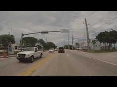 two cars driving down the street in front of an intersection