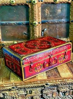 an ornately decorated box sitting on top of a wooden table