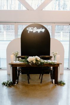 a table with flowers and candles on it in front of a sign that says the big apple