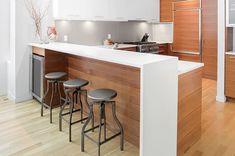 a kitchen with an island and three stools