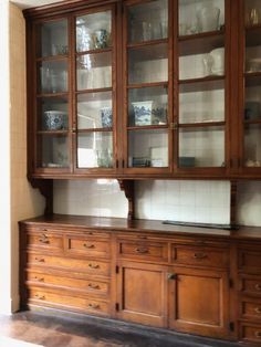 an old fashioned wooden china cabinet with glass doors