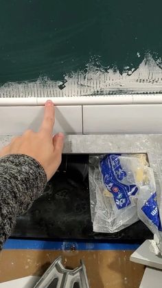 a person's hand on the edge of a boat with food and water in it