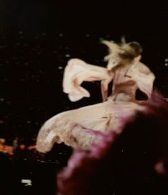 a blurry photo of a woman with her hair blowing in the wind on top of a building