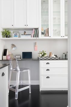 an office with white cabinets and black counter tops