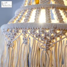 a white crocheted light hanging from a ceiling