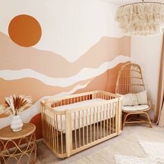 a baby's room with a crib, rocking chair and wall mural in the background