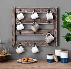 a wooden rack with coffee mugs hanging from it's sides on a wall