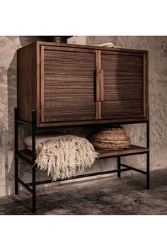 a wooden cabinet sitting on top of a shelf next to a wall mounted clock and wicker basket