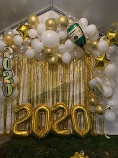 balloons and streamers decorate the entrance to a new year's eve party in gold