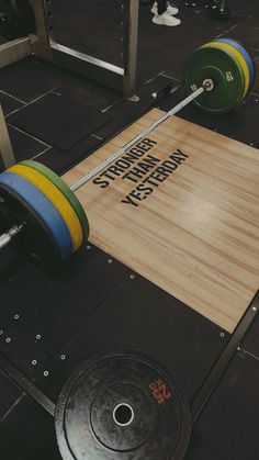 a barbell sits on top of a gym floor with the words strength and energy printed on it