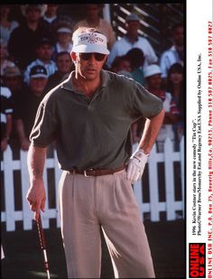 a man holding a golf club in front of a crowd