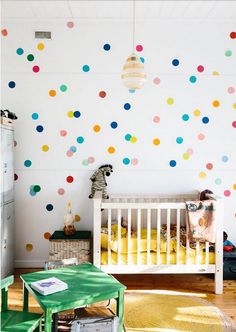 a child's room with colorful polka dots on the wall