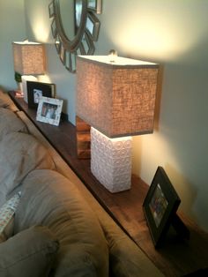 a living room with two lamps and pictures on the table