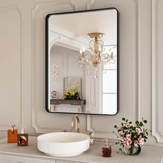 a bathroom vanity with a large mirror above it and flowers in the vase on the counter