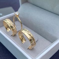 two gold wedding rings in a box