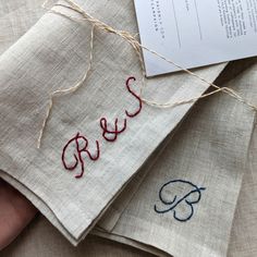 three pieces of cloth with embroidered words on them, and a piece of paper in the middle