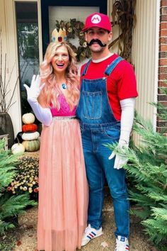 a man and woman dressed up as mario and luigi in front of a house with plants