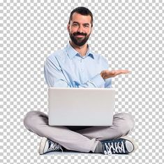 a man sitting on the floor with his laptop in front of him and pointing at something