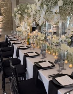 the tables are set with black and white linens, silverware, candles, and flowers