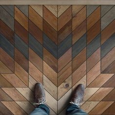 a person standing on top of a wooden floor next to a tiled floor with wood floors