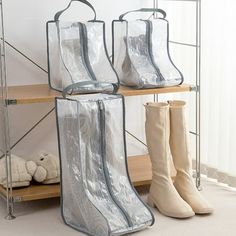 three pairs of boots are sitting on a shelf next to two bags and one bag