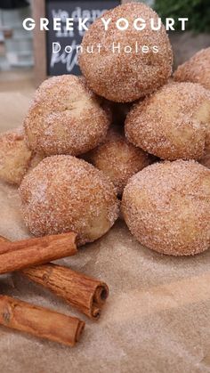 cinnamon sugar donuts are piled on top of each other with cinnamon sticks next to them