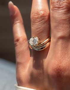 a close up of a person's hand with a diamond ring on their finger