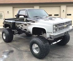 a silver truck with flames painted on it