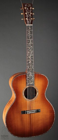 an acoustic guitar is shown against a gray background