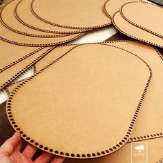 several pieces of cardboard with holes cut out on the side to make decorative wall hangings