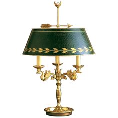 a lamp that is sitting on top of a wooden stand with a green shade over it