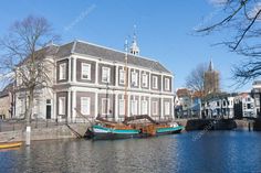 a boat is docked in front of a building on the water