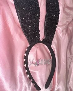 a black bunny ears headband with pearls on it