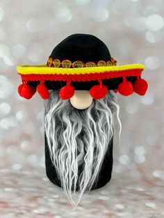 an old man with long white hair wearing a black hat and red tassels