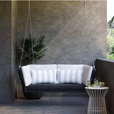 a black and white couch sitting on top of a porch next to a potted plant