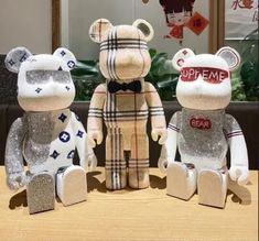 three teddy bears sitting on top of a wooden table